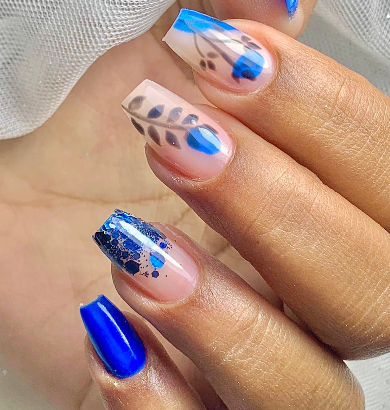 Nail art em tons de azul com folhas e detalhes delicados