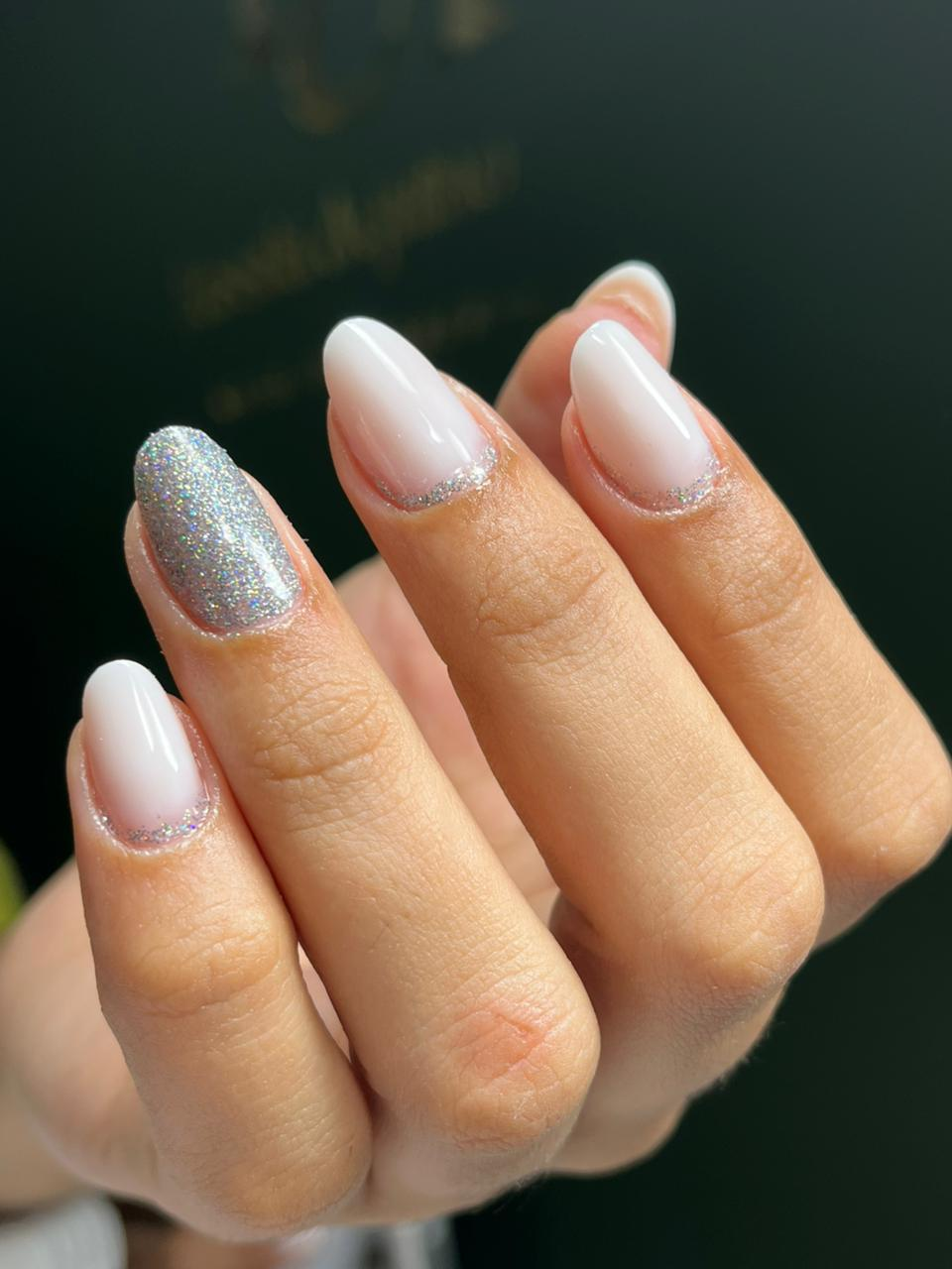 Unhas amendoadas em branco leitoso com detalhe em glitter prateado