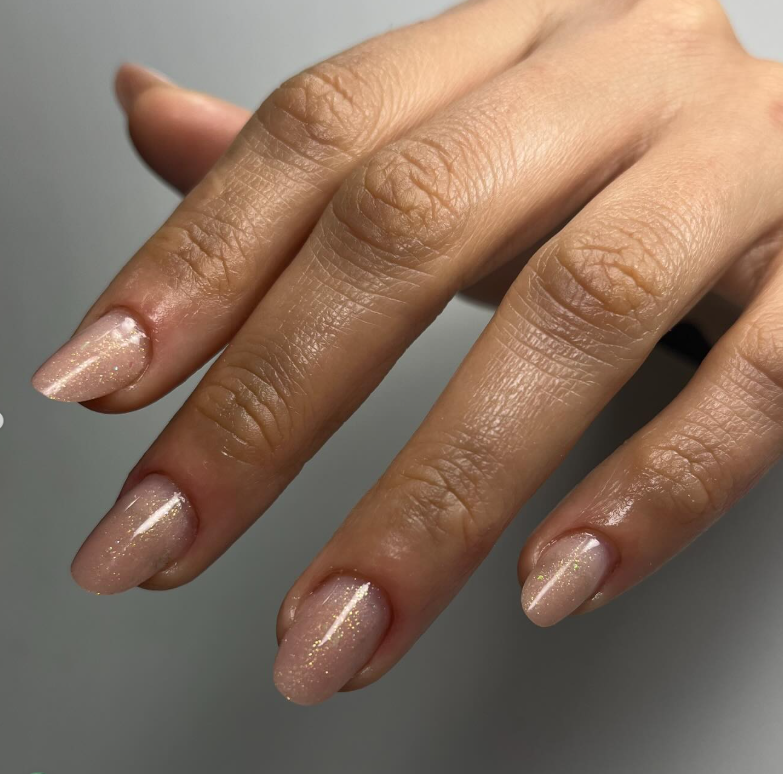 Unhas nude com glitter dourado discreto