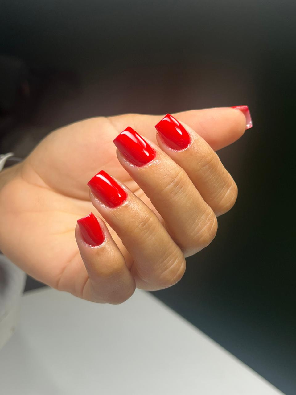 Unhas curtas em vermelho clássico com brilho intenso